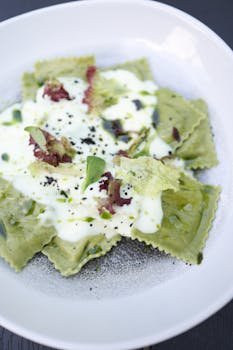 pexels-photo-17628608-17628608 Delicious green ravioli topped with creamy sauce and herbs. Perfect gourmet meal.