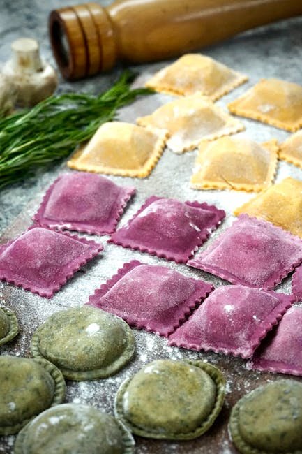 A variety of colorful ravioli on a floured kitchen countertop. Perfect for Italian cuisine enthusiasts.